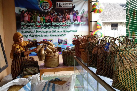 Mariatul Asiah among the purun handicrafts that she markets through Komunitas Pelangi. © Budi Kurniawan